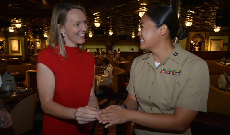 Navy veteran Vera Lannek vice president of strategic sourcing for Carnival Corporation shares a commemorative coin with a service member